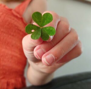 Child's hand holding a clover.